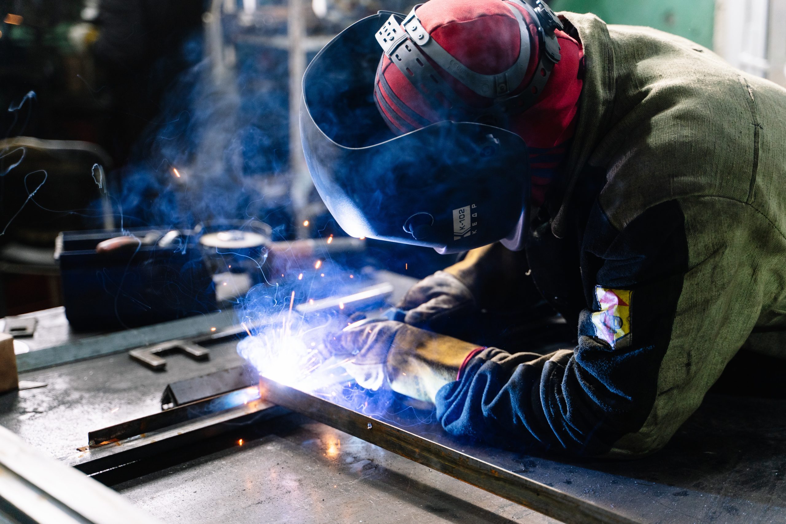 A welder in protective gear welds while at work
